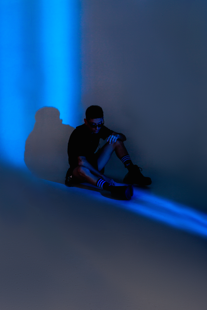 A man sits alone in a dark room. 